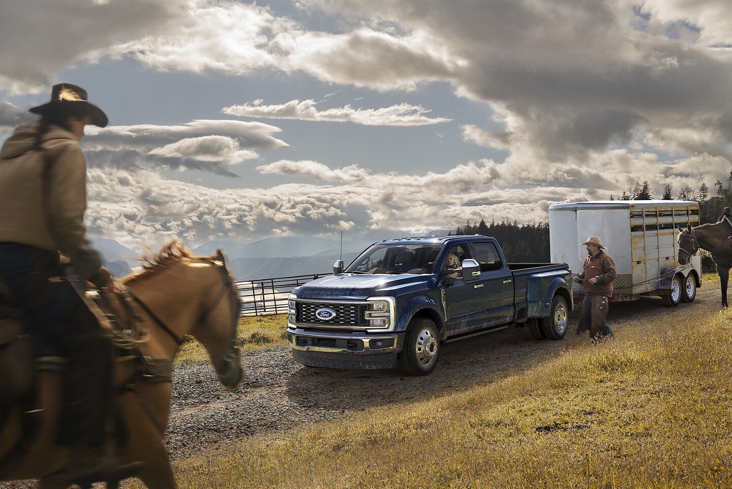 Ford F-series Super Duty truck pulling a large horse trailer, parked in a mountainous trail road