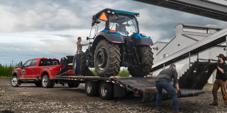 A couple guys loading a tractor on to a Trailor to be towed by a 2025 Ford Super Duty.