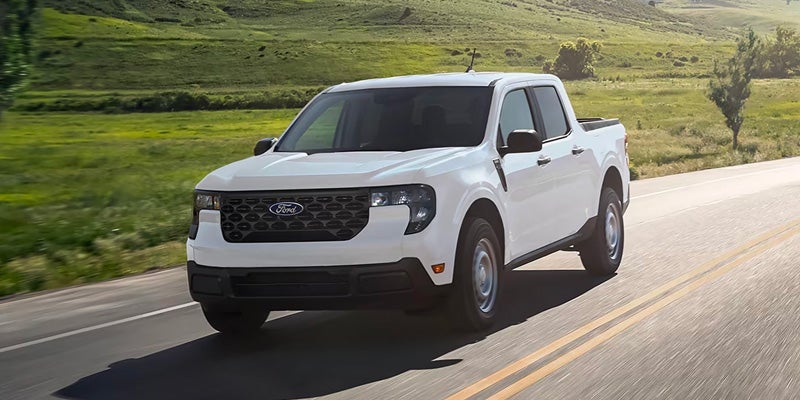 a white 2025 Ford Maverick driving on a country road