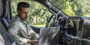 A man working from a 2025 Ford F-150 Raptor.