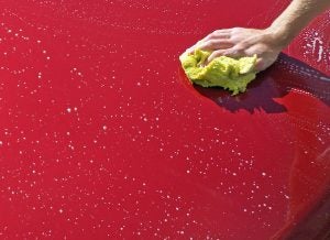 a hand performing DIY car detailing on it's vehicle