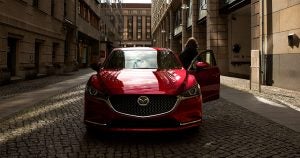 A woman stepping out of the driver door of a red 2019 Mazda6 in Wichita, KS
