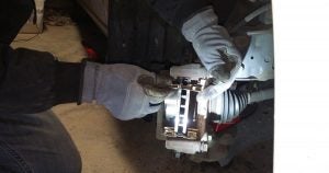 A mechanic at Davis-Moore Mazda evaluating brakes on a vehicle in Wichita, KS
