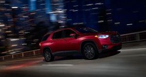 A red 2019 Chevy Traverse driving at night in Wichita, KS