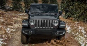 A recent college grad driving a black Jeep Wrangler on an off-road path near Wichita, KS