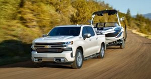 A white Chevy Silverado 1500 truck towing a boat near Wichita, KS