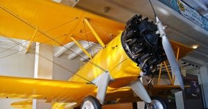 A yellow bi-plane on display at the Kansas Aviation Museum in Wichita, KS.