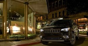 A black 2020 Jeep Cherokee driving at night on the streets of Wichita, KS