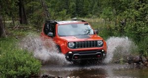 An orange 2019 Jeep Renegade driving through a creek near Wichita, KS