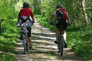 Two People Cycling on Bike Path