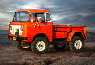A sideview of a 1957 Jeep FC-150 in red