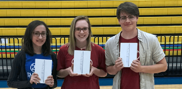 3 students in school auditorium with ipads
