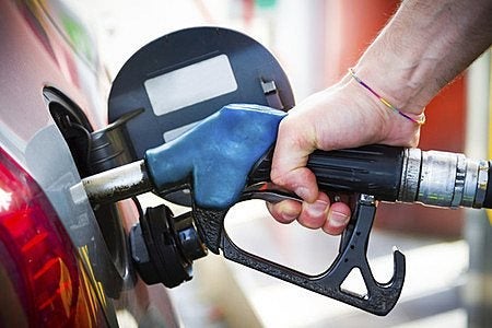 blue gas pump in a silver car held by an arm