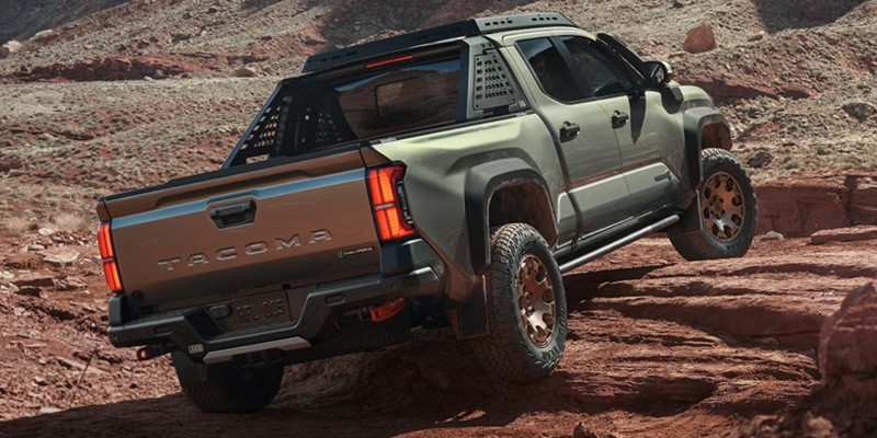 A Toyota Tacoma navigating rocky terrain, promoting spring truck buying in El Paso, TX.