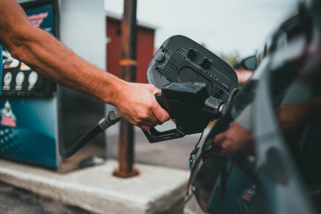 Person putting fuel in a vehicle