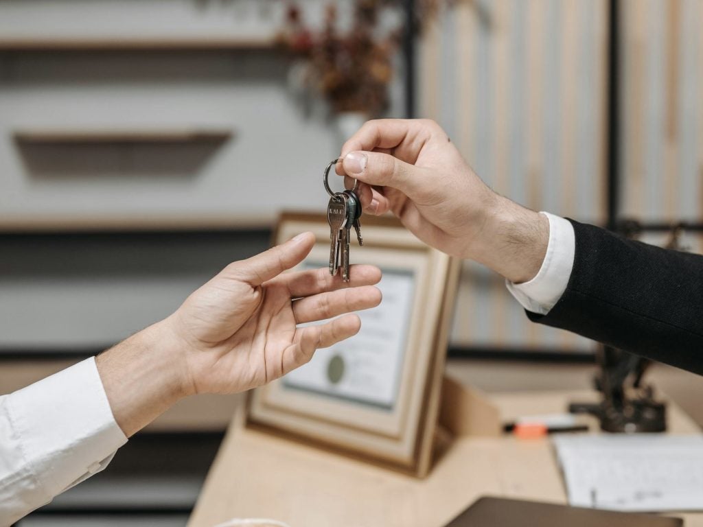 salesman handing over the keys to customer buying a vehicle