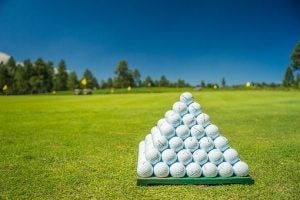 golf balls stacked in a pyramid on a gold course 