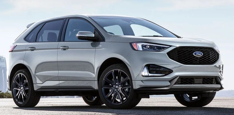 Silver 2021 Ford Edge Parked in front of city view.