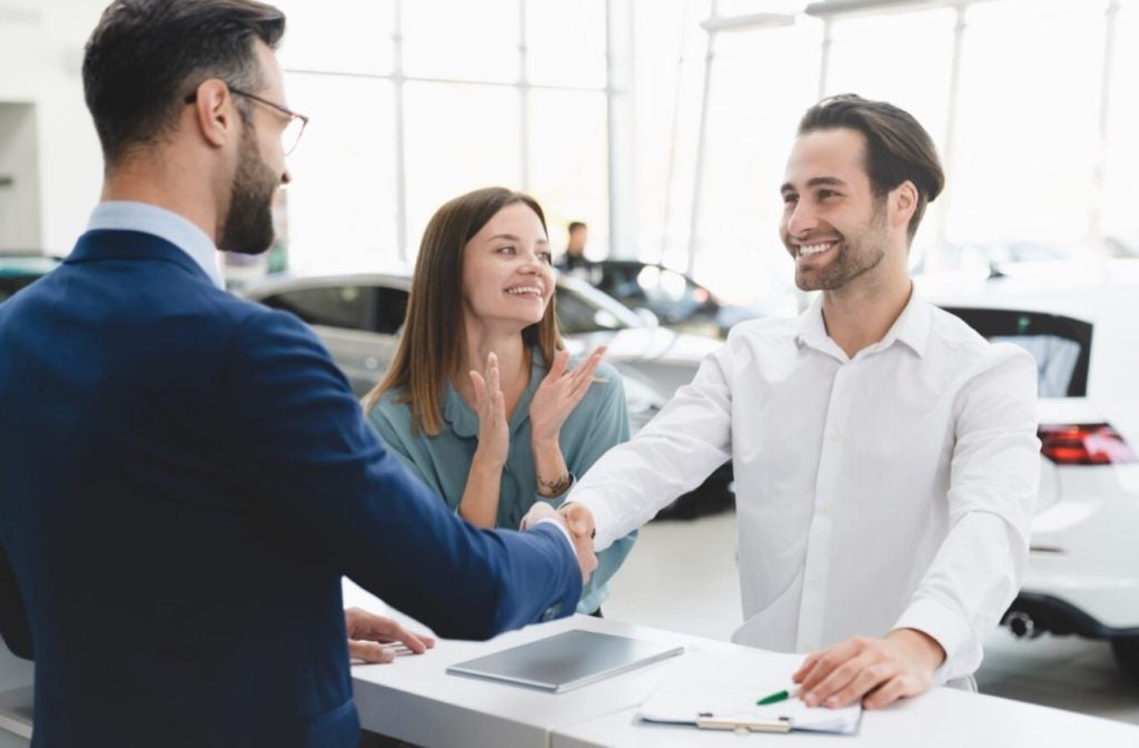 a couple full of smiles at a Ford dealership who just got approved for their Ford financing.