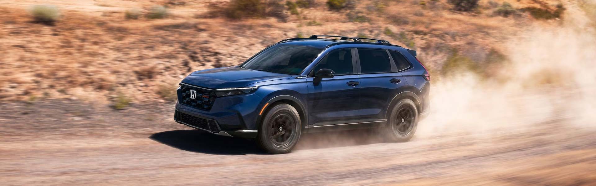 Honda SUV kicking up dust off-road.