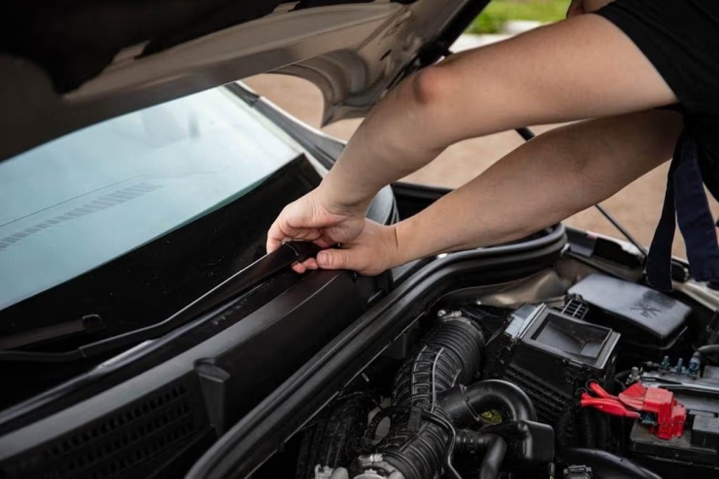 A person changing out their windshield wipers.