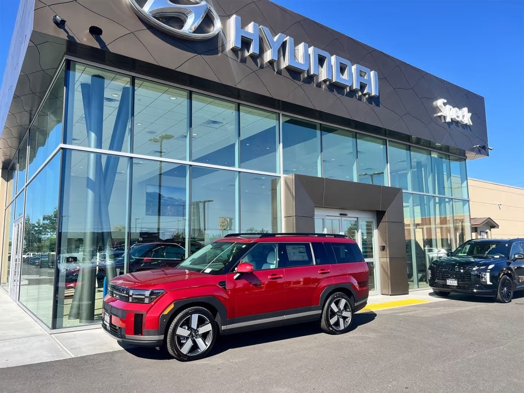 A red Hyundai SUV parked in front of Speck Hyundai car dealership.