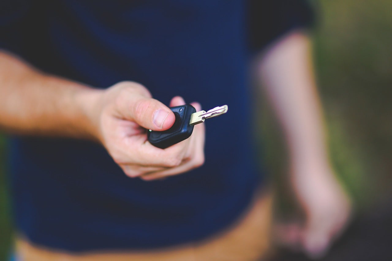 A person holidng a pair of car keys
