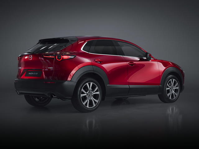 A red Mazda SUV in a dark gray background