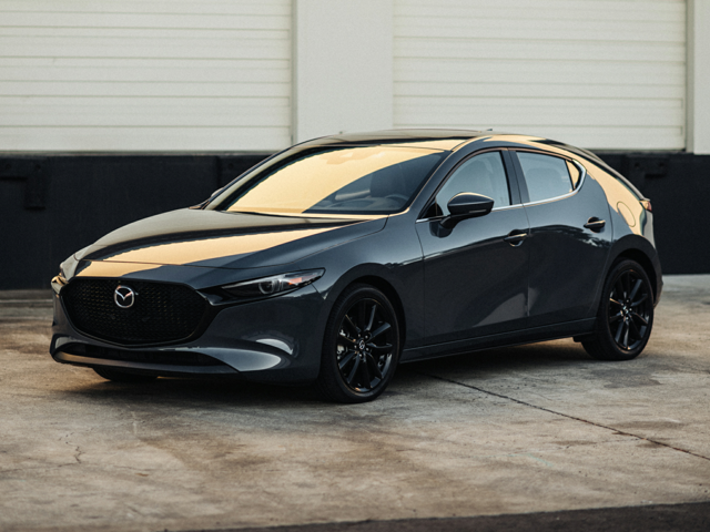 A Mazda parked by a garage