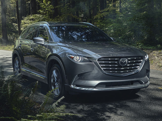 A Mazda SUV driving on a road