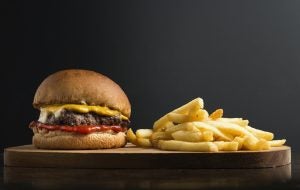 Burger and fries on wood board