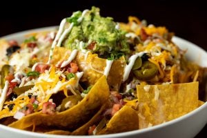 Plate of loaded nachos with guacamole