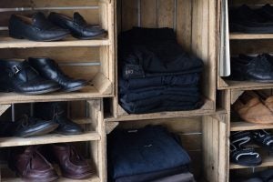used jeans and shoes on a wooden shelf 