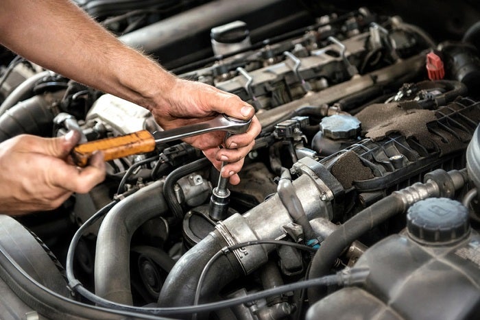 Mechanic working under the hood at a Mazda service appointment