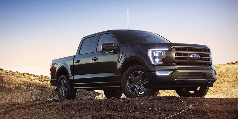 A black pickup truck parked on rugged terrain, showcasing strength and off-road capability.