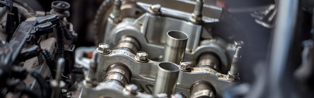 Mechanical engine camshaft and valve components close-up.