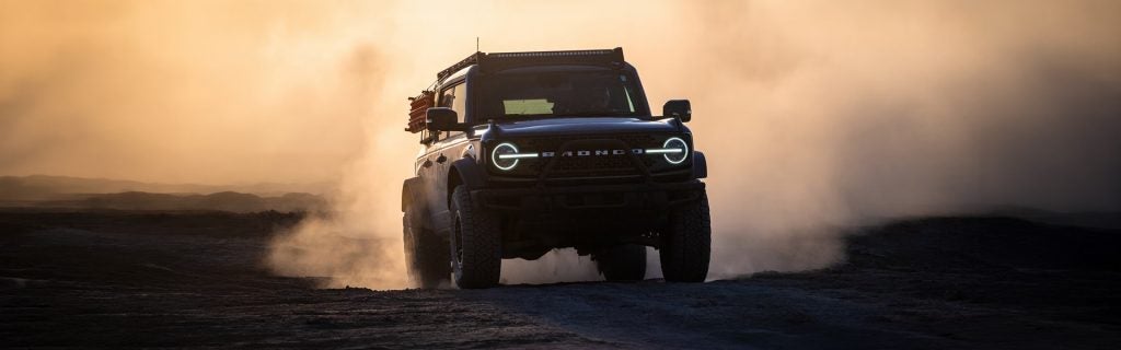 A rugged off-road SUV driving through dusty terrain, showcasing power and adventure capability.