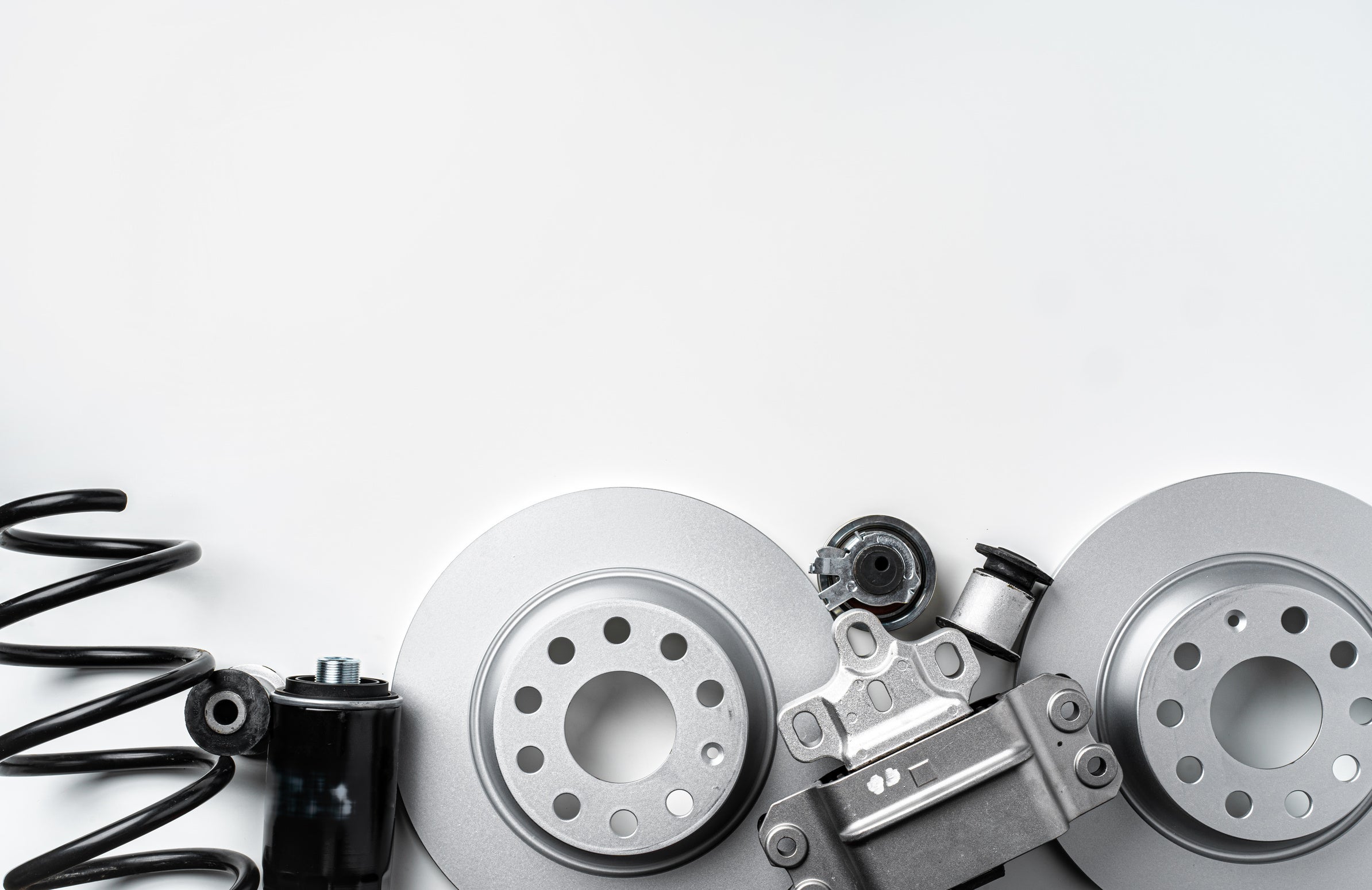 Brake discs, suspension components and other automotive parts on a light background