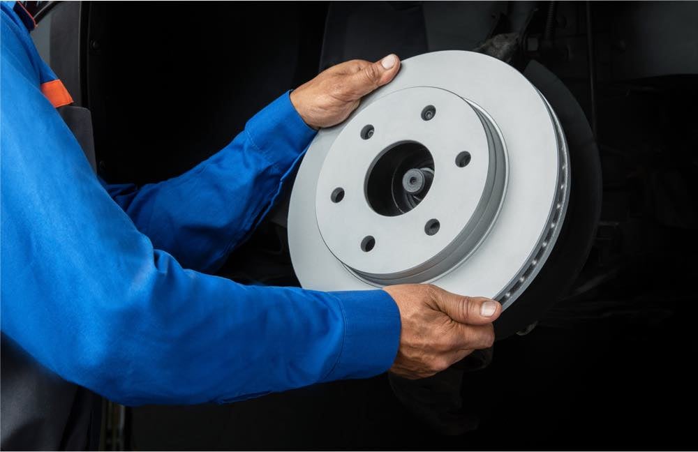 Quick Lane technician installing a brake rotor
