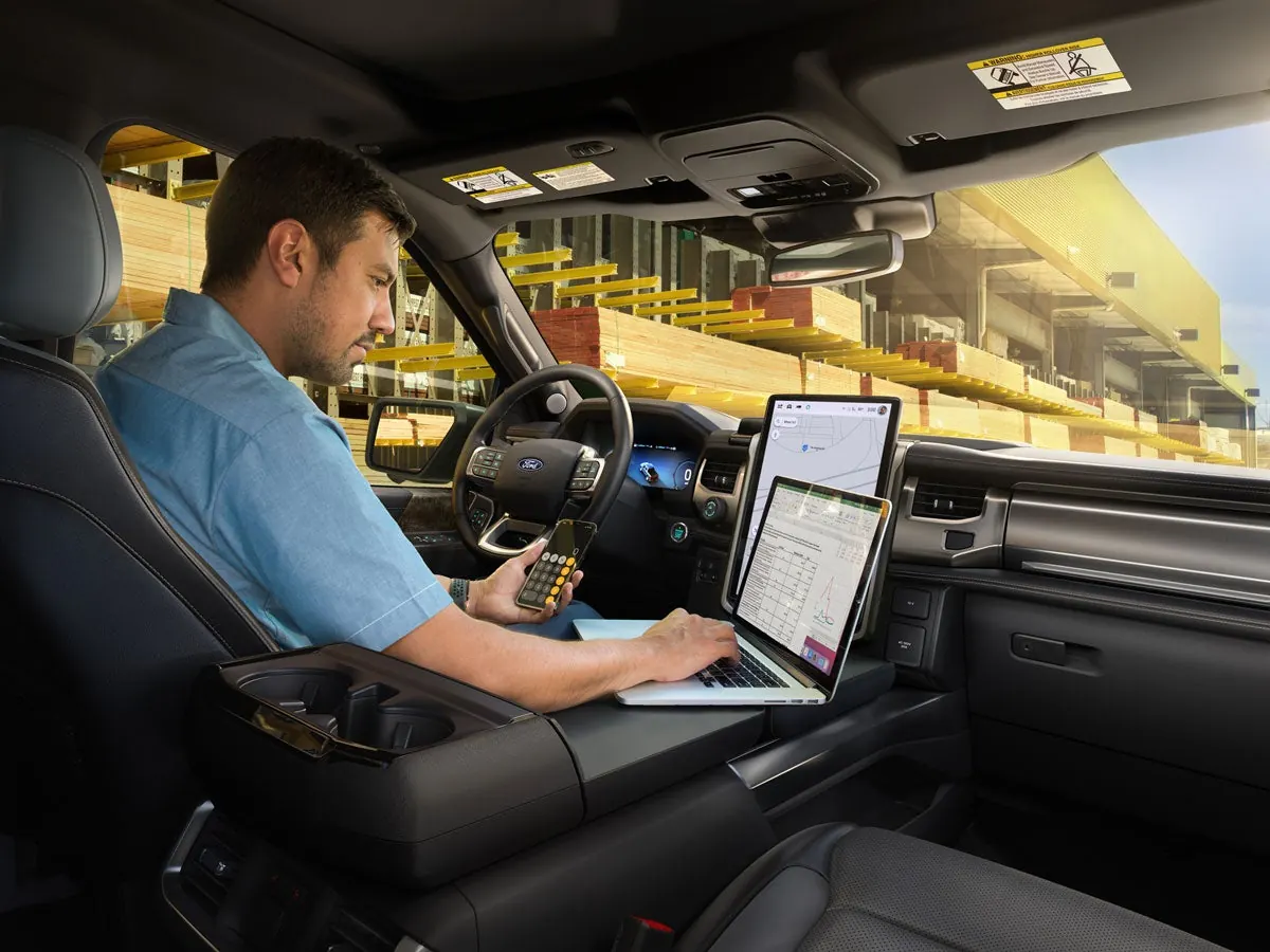 Man working on a laptop on the F-150 Lightning Interior Work Surface