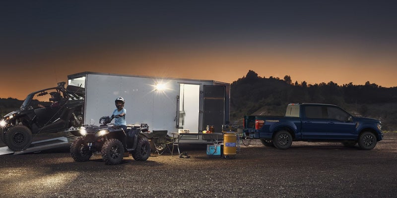 A 2025 Ford F-150 Tremor shown hauling a trailer of All Terrain Vehicles (ATVs)