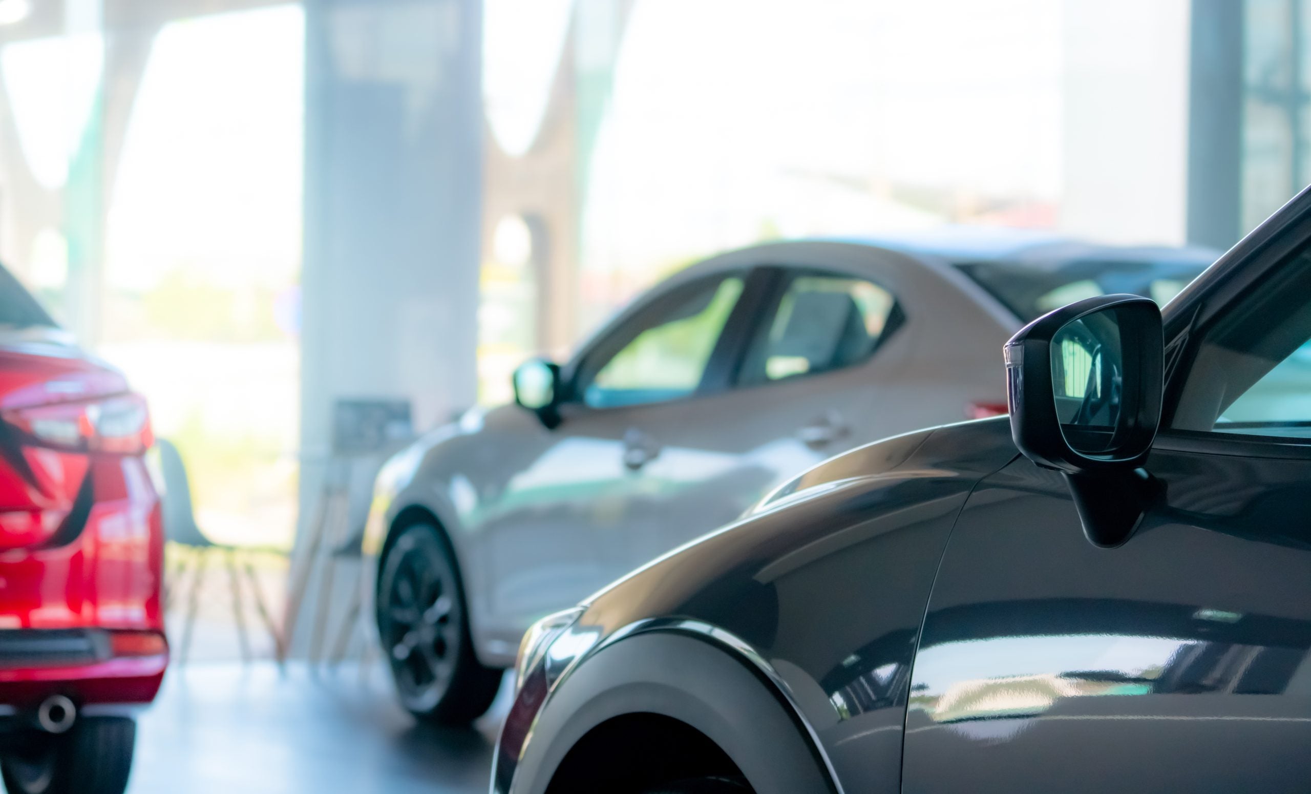 Selective focus car parked in luxury showroom. Car dealership office. New car parked in modern showroom. Car for sale and rent business. Automobile leasing and insurance concept. Electric automobile.