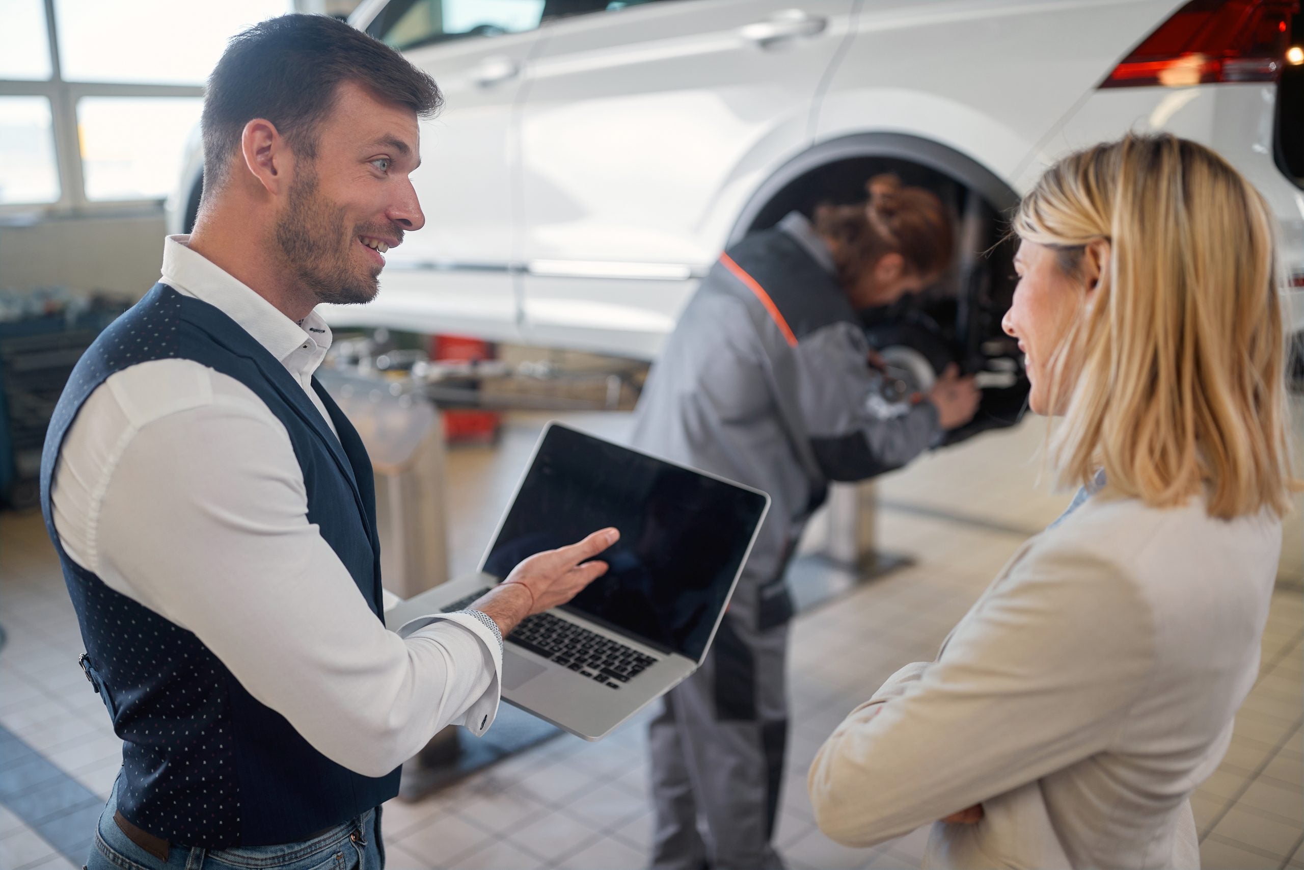 Client and employee looking diagnostic on engine