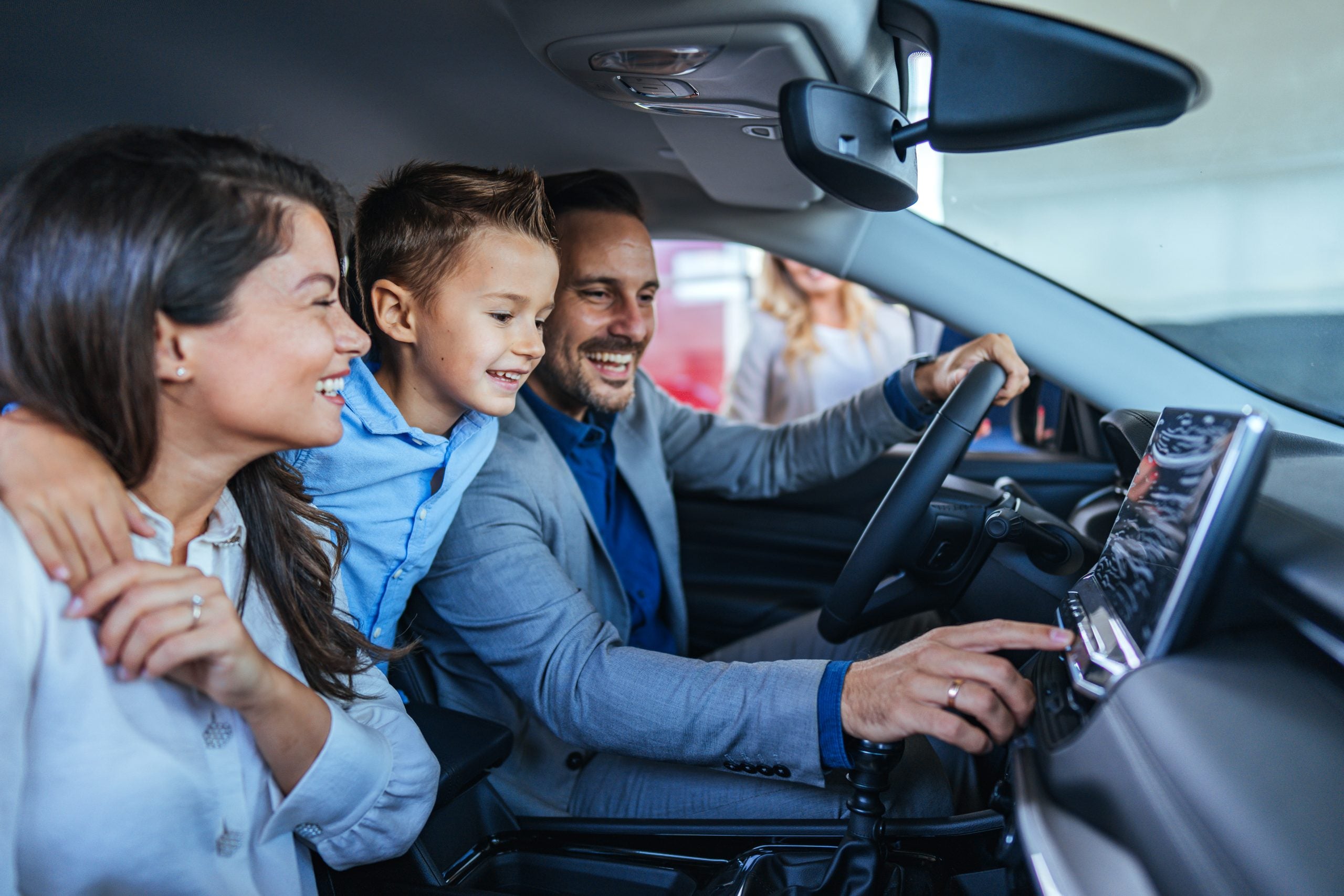 Happy Family Exploring New Car Interior at Dealership