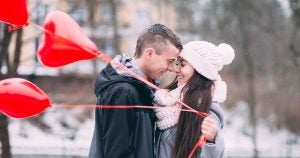 A man and a woman on a date holding heart shaped balloons in Sheboygan, WI