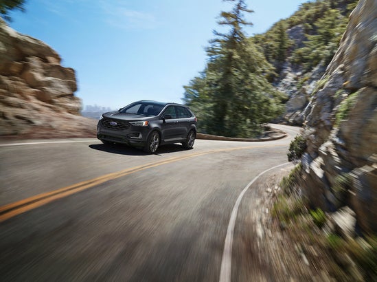 silver ford edge speeding down a mountain road 