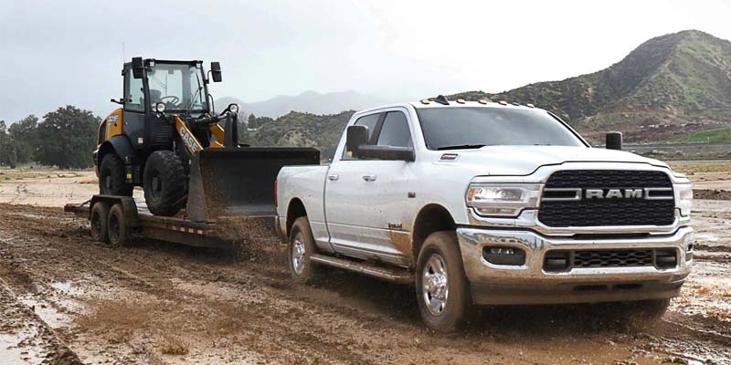A 2023 RAM 2500 towing a tractor on a muddy road near Lancaster, OH