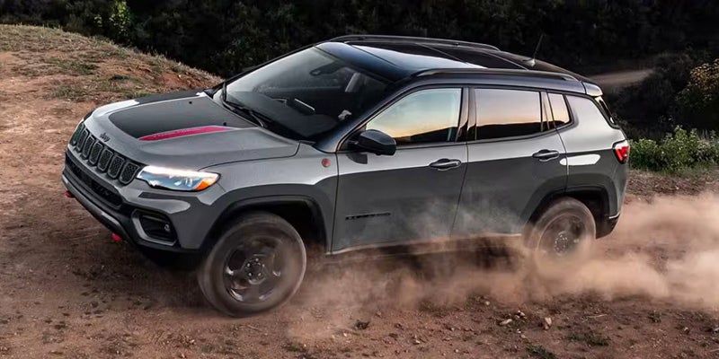 2024 jeep compass driving down a dirt road