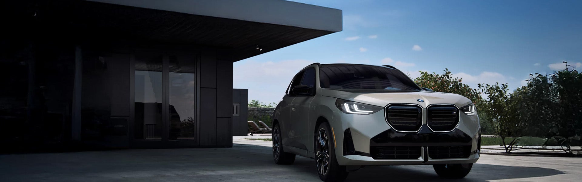 A sleek BMW SUV parked in front of a modern building with a clear blue sky above