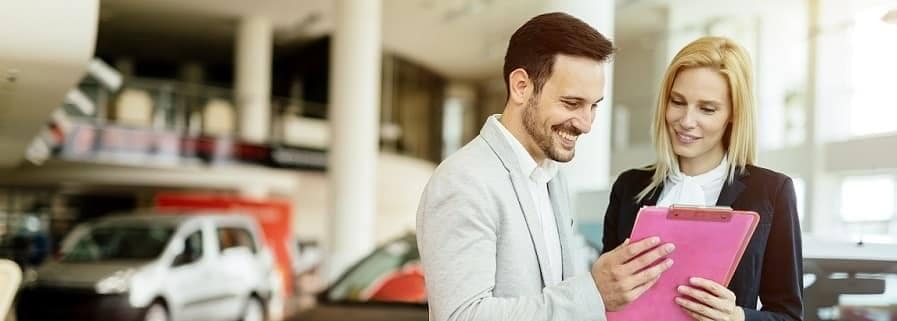 Wallace Auto sales person hands customer a copy of vehicle history report.